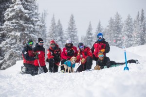 Ski patrollers at avalanche dog course with dog 